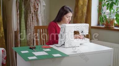 美丽的黑发女人正在调整缝纫机。